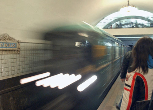 Imagen del metro de Moscú. En el andén, una mujer de espaldas esperando mientras pasa un tren