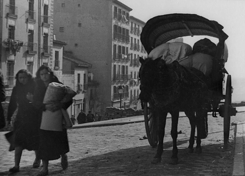 Dos mujeres andando junto a un carro de caballos en Madrid durante la Guerra Civil española