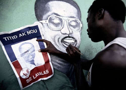  Haitiano copiando el retrato de Aristide en una fachada de Puerto Príncipe